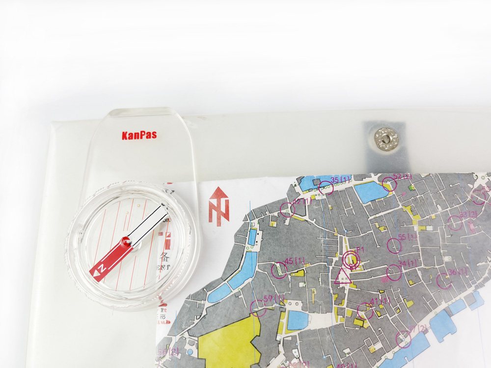 Mountain bike orienteering (MTBO) compass mounted on a bike map holder.