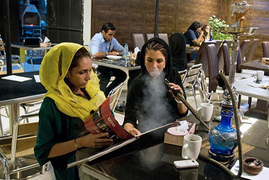 Iranian smoking hookah while drinking tea