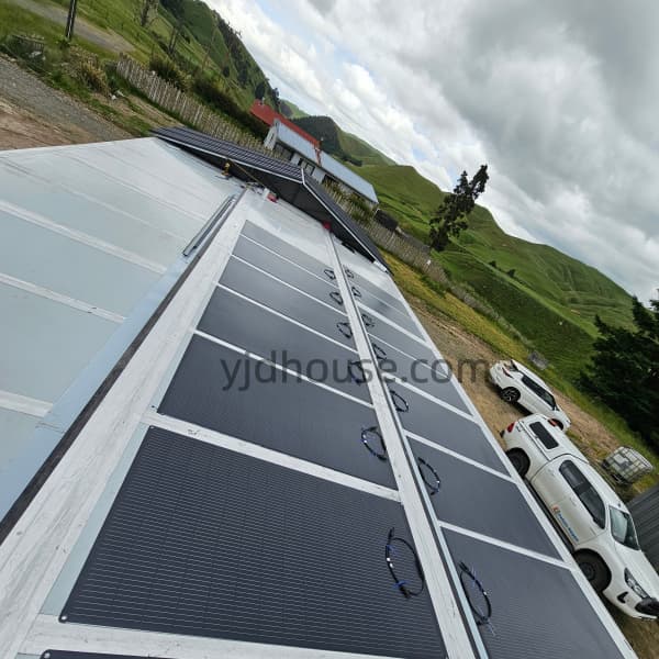 Flexible solar panels installed across the roof of a container house