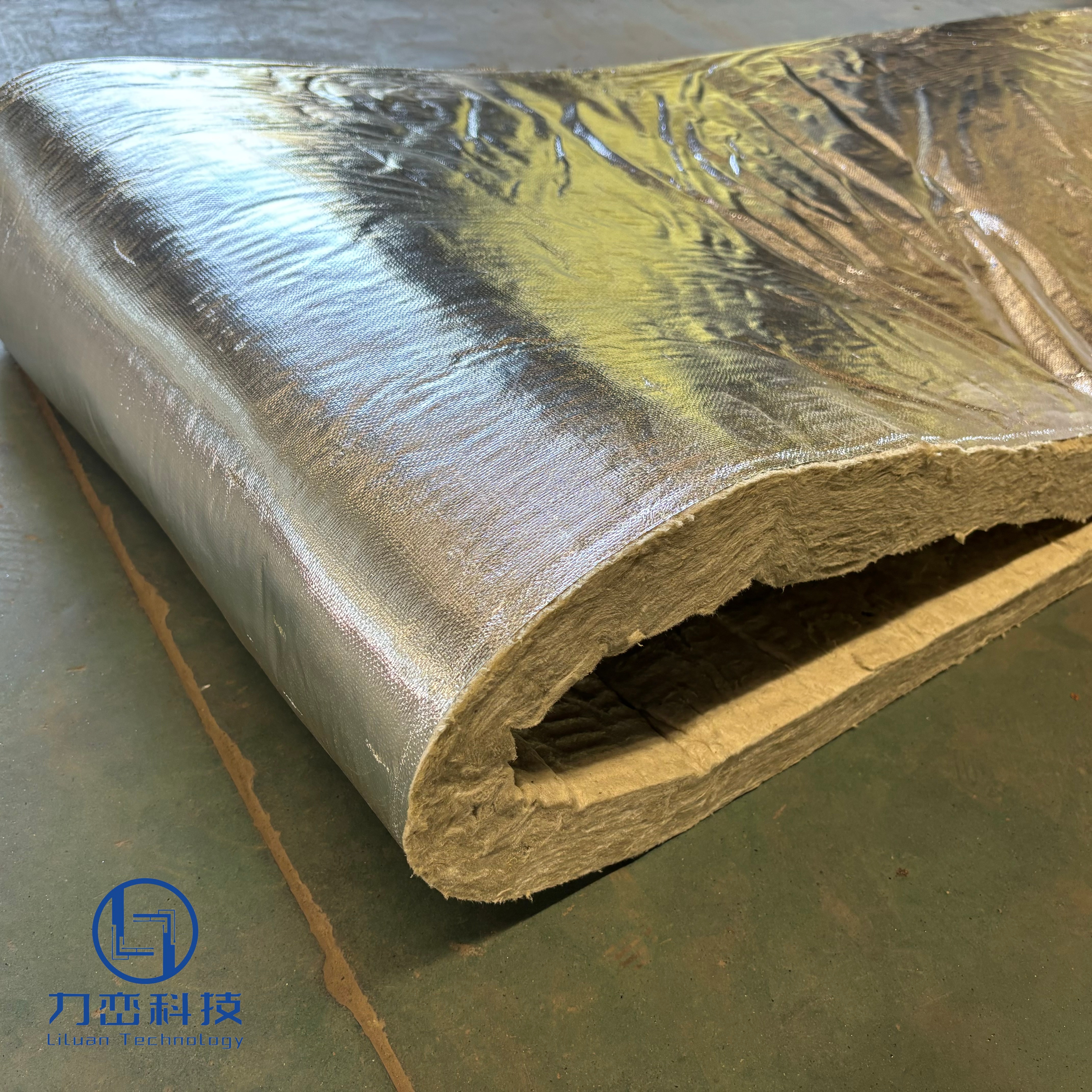 Foil faced rock wool roll blanket close-up showing shiny aluminum foil vapor barrier and dense yellow fiber core – high-performance thermal and acoustic insulation by Liluan Technology