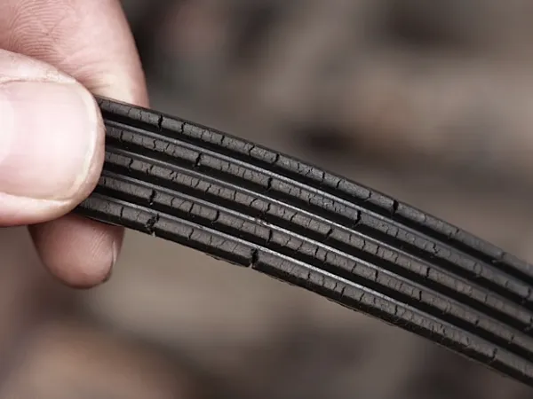 Worn serpentine belt with cracks and glazing showing common failure symptoms
