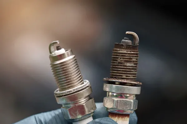 Bad spark plug symptoms shown by carbon buildup oil fouling and wear