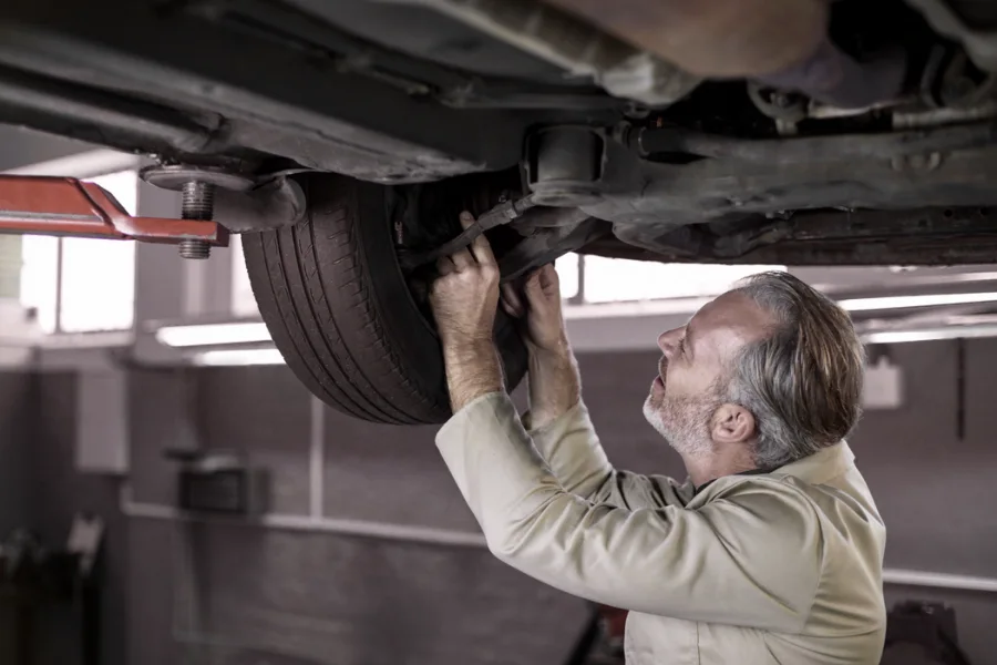 Squeaky Suspension: Here’s What It Means and How to Fix It – technician diagnosing suspension noise