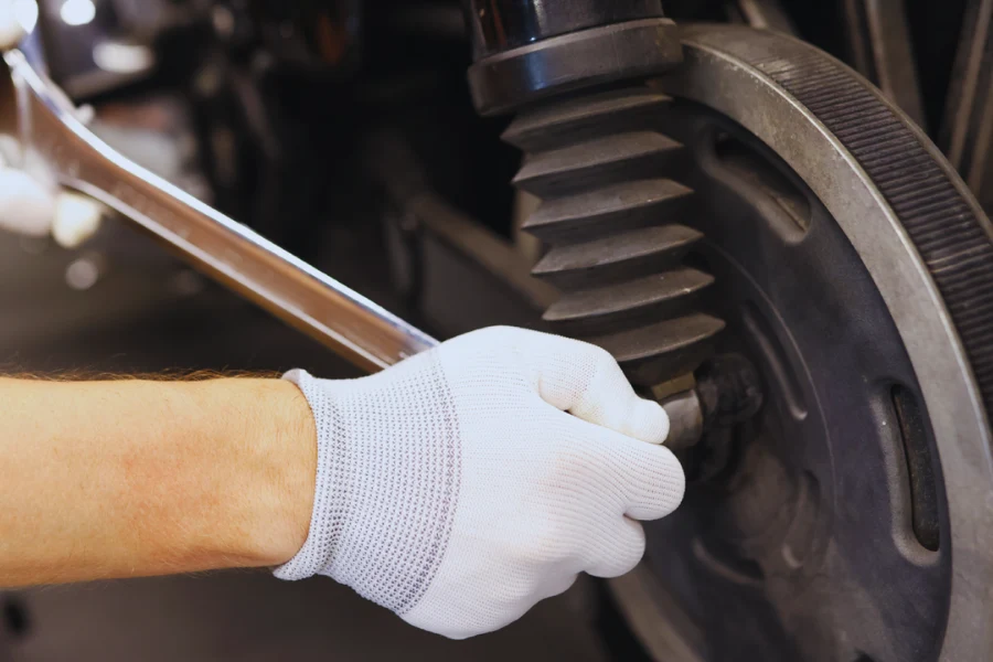 Mechanic replacing a leaking shock absorber, highlighting the importance of timely replacement to restore vehicle stability and safety.