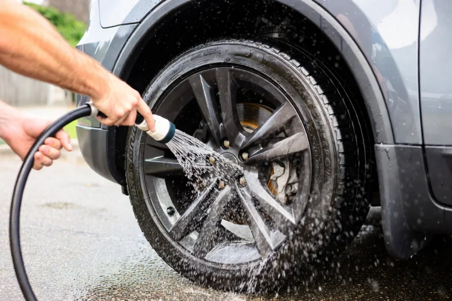 Thoroughly rinsing wheels to wash away brake dust and cleaning solution, a crucial step in cleaning brake dust off your wheels.