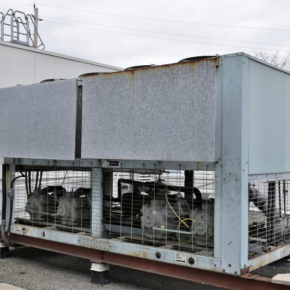 Air-cooled chiller on a rooftop, semi-hermetic compressors behind the access grille