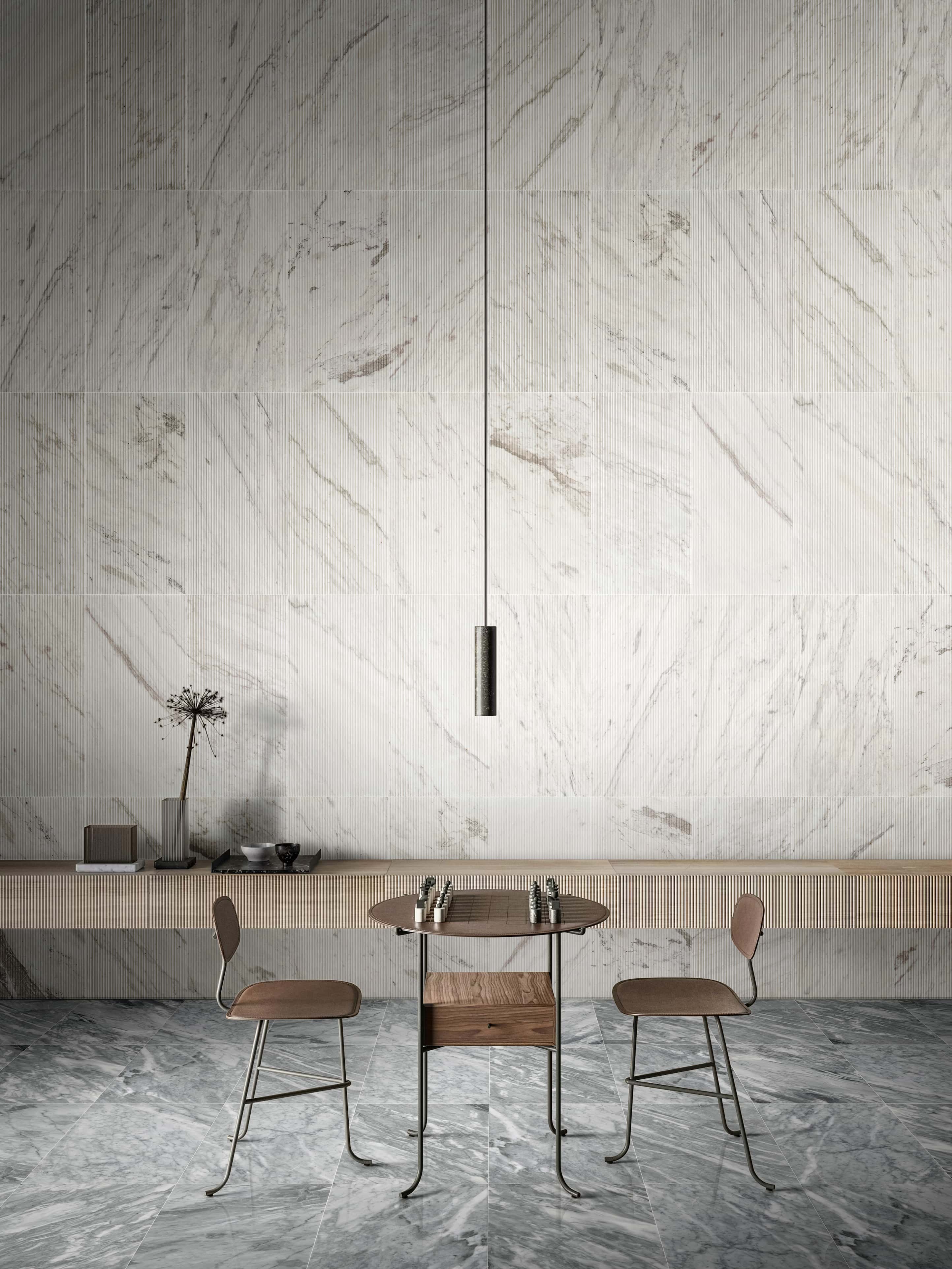 Striking interior design pairing 12x24 Carrara Gray polished marble floor tiles with Snow Mountain White 3D fluted wall tiles.