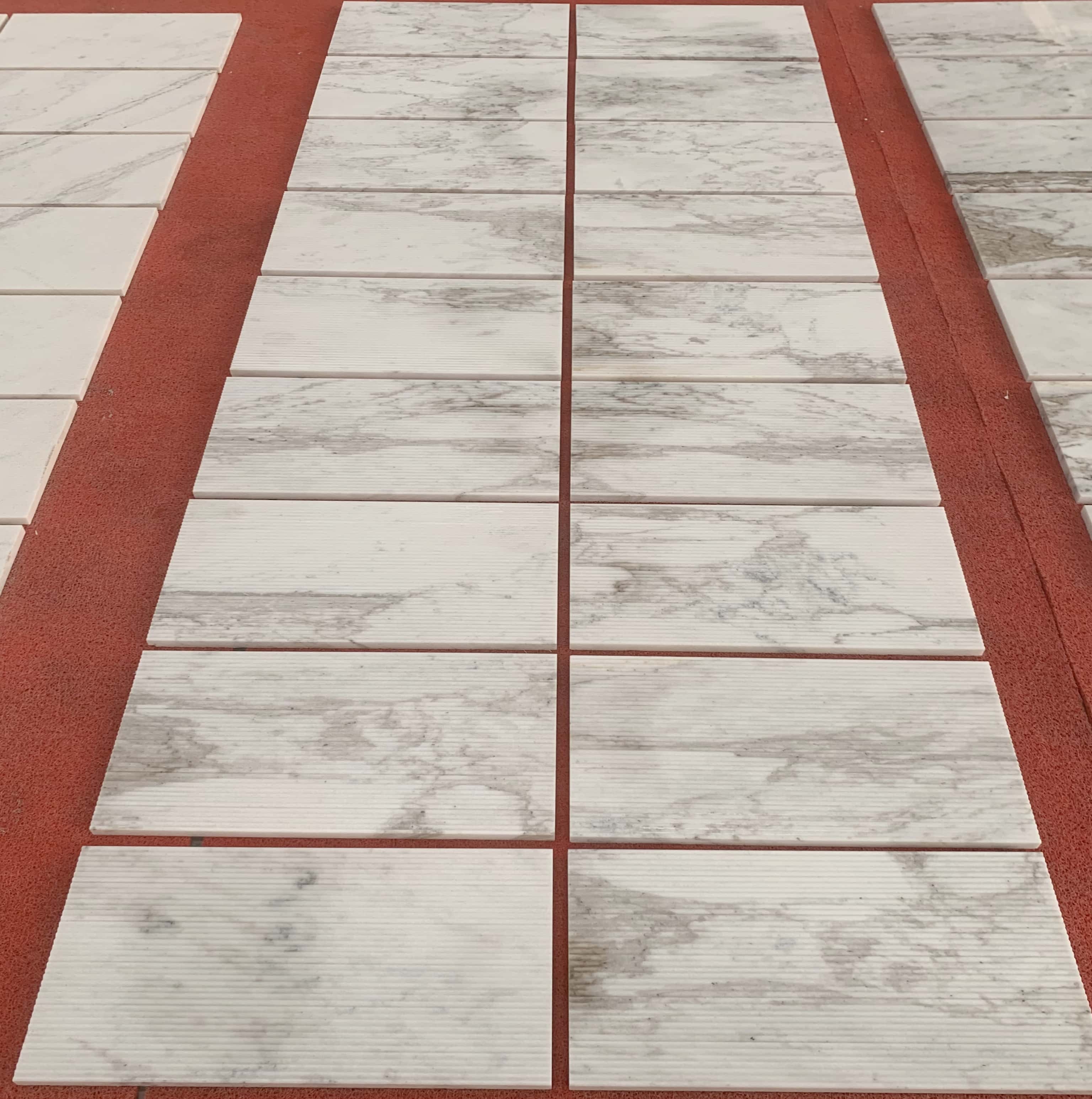 Expansive layout of 100% natural Snow Mountain White fluted marble tiles, showcasing unique grey veining and US warehouse ready-to-ship stock.