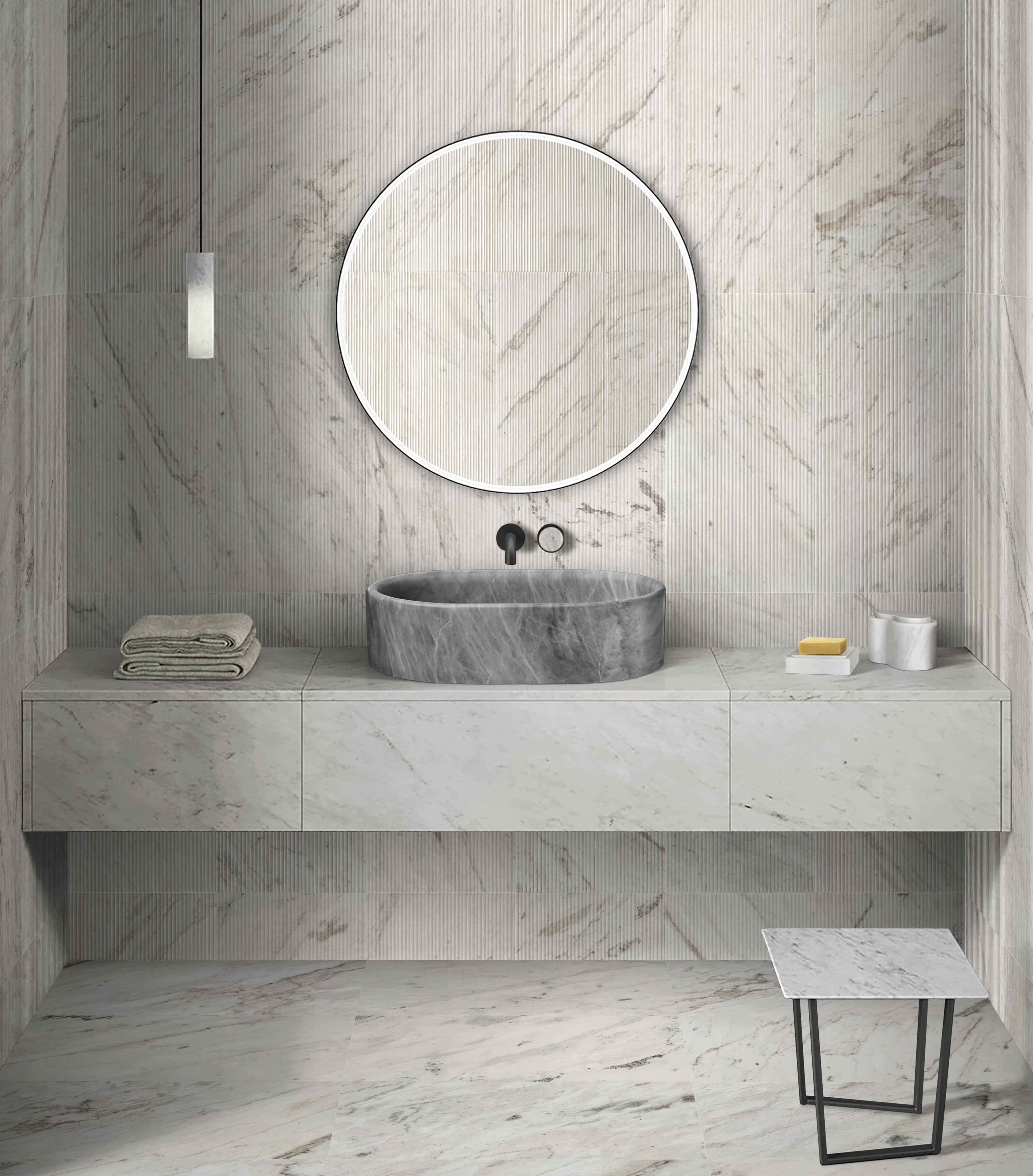 Beautiful contrast in a modern bathroom using a Carrara Gray natural marble vessel sink and Snow Mountain White fluted wall tiles.