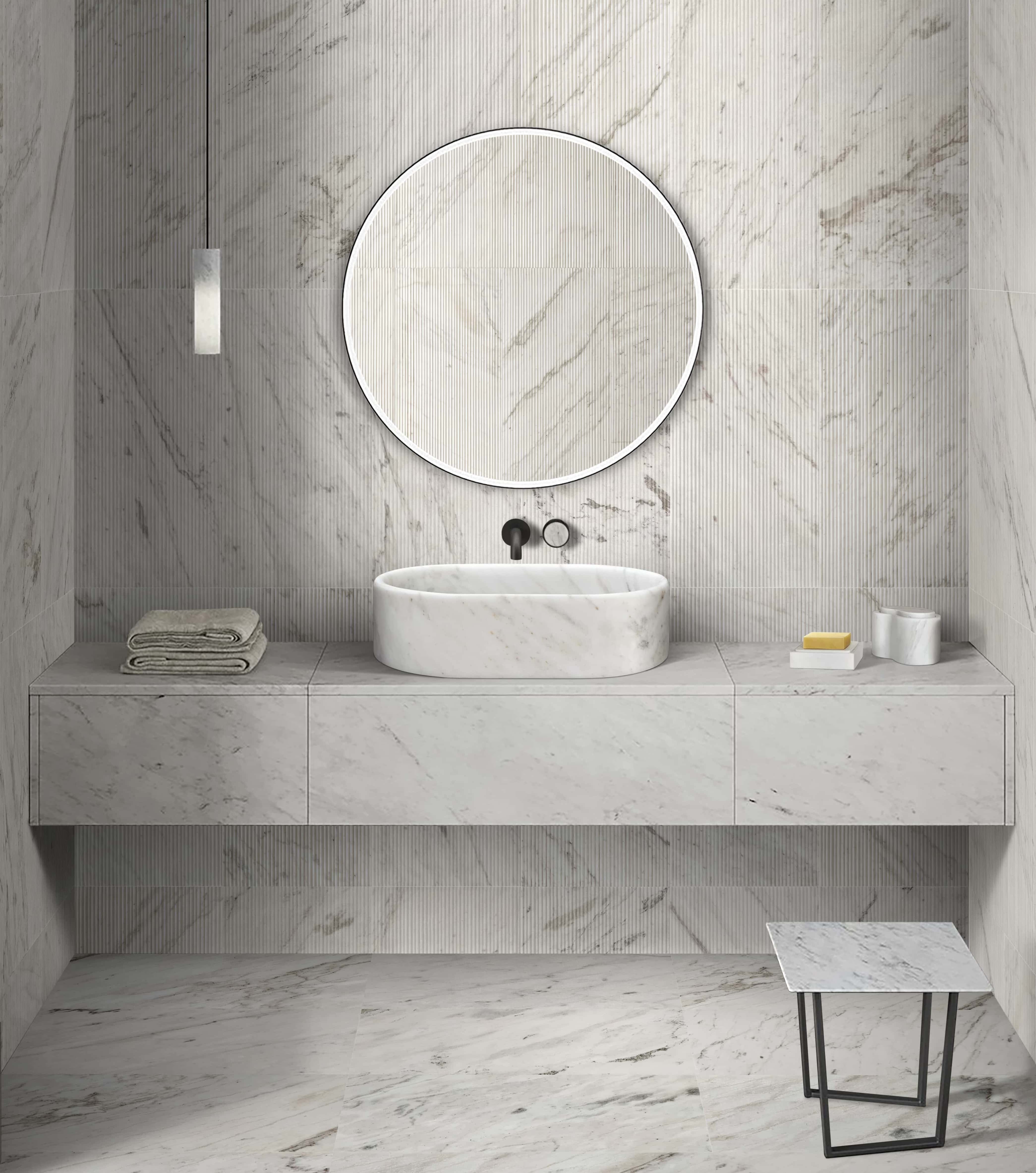 Elegant bathroom vanity featuring a Snow Mountain White solid marble oval sink against a textured ribbed white marble wall.