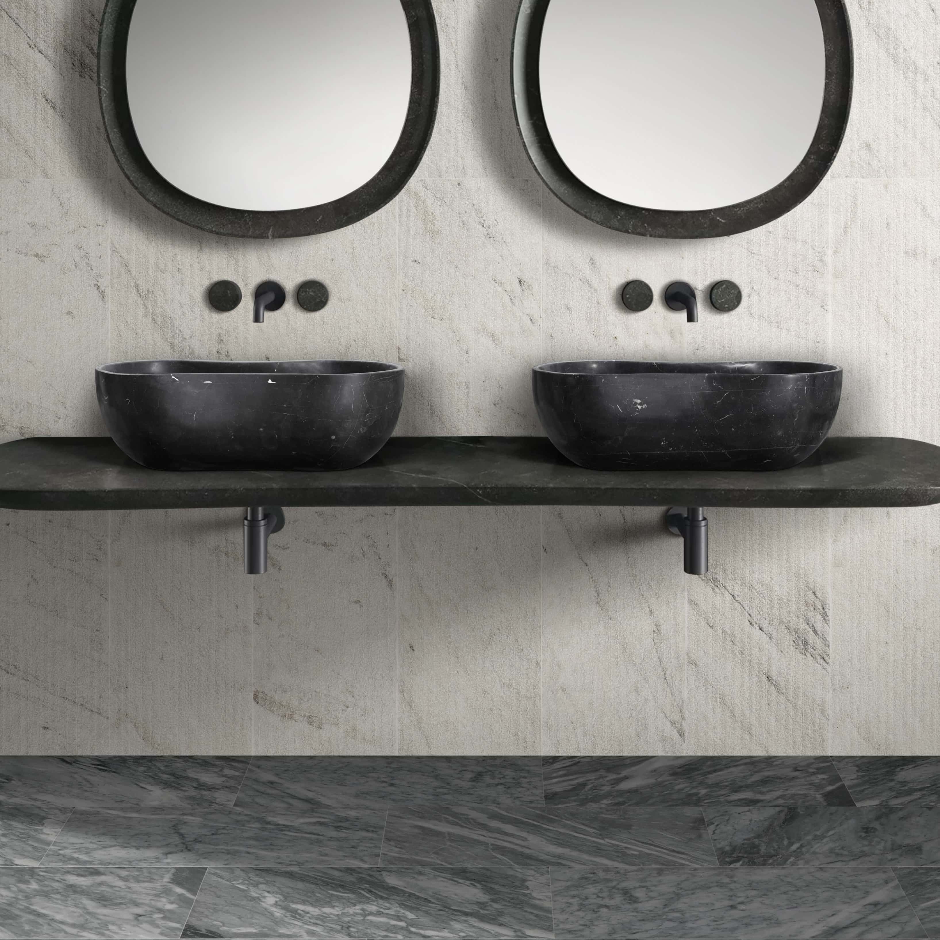 Two honed Olive Black marble wave vessel sinks on a black vanity, paired with Carrara Gray polished floor tiles and Snow Mountain White FS textured wall tiles.