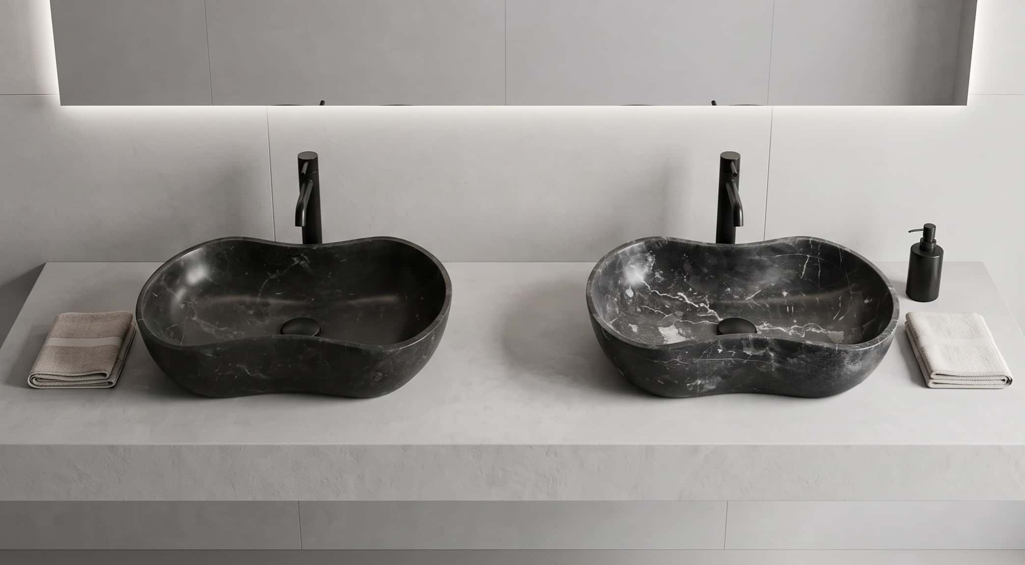 A side-by-side comparison of two Olive Black marble wave vessel sinks, demonstrating the unique veining variations and honest natural character of the stone blocks.