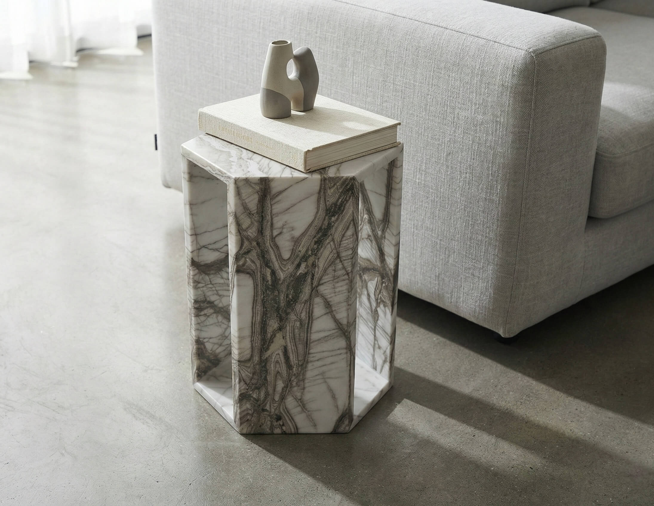 Arboris White marble hexagon side table paired with grey sofa in Japandi living room.