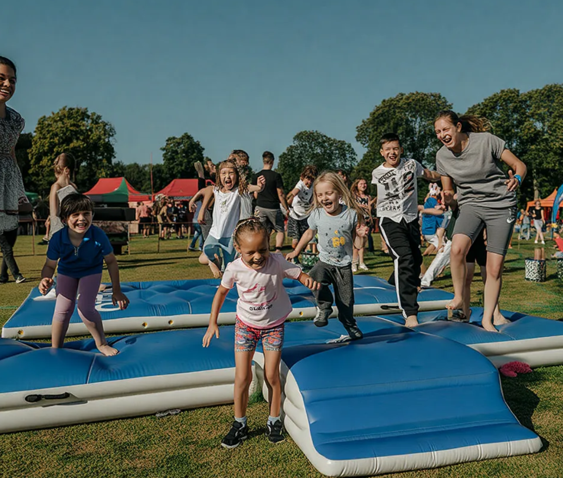 Large inflatable tumble track mat setup at an outdoor rental event, showcasing its use as a profitable, temporary entertainment attraction.