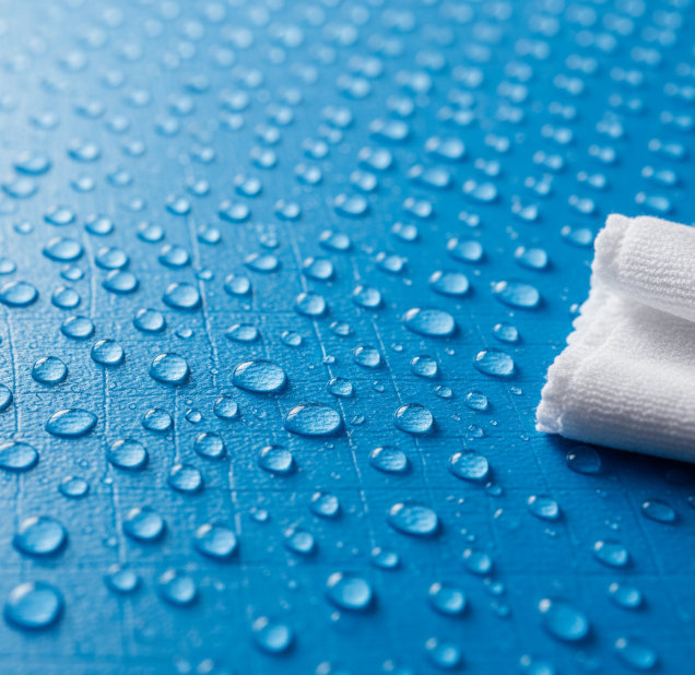 Water droplets beading on a waterproof PVC gymnastics mat surface, demonstrating its easy-to-clean material