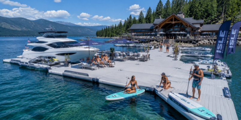 Luxury lakeside resort with connected modular inflatable docks creating an expansive floating platform for guests and water activities