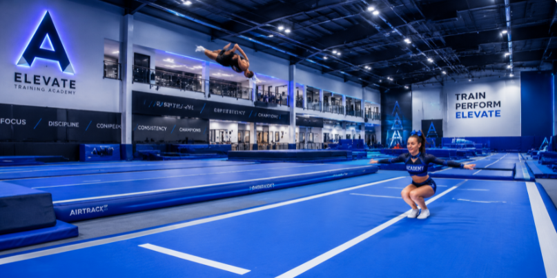 Modern editorial vector illustration of premium oversized air track mats inside a bustling commercial sports academy