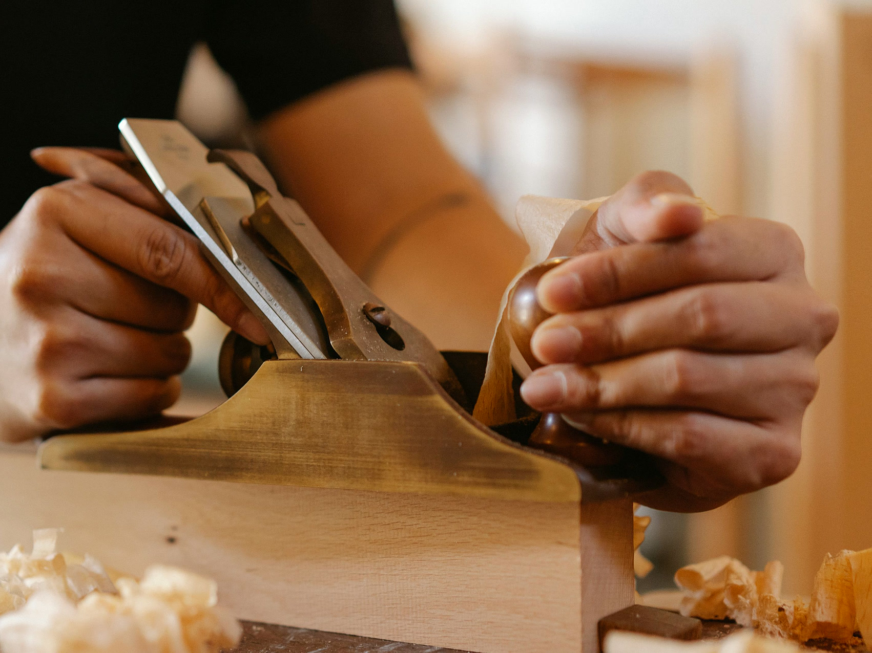 Craftsman hand-planing a timber board in the joinery workshop
