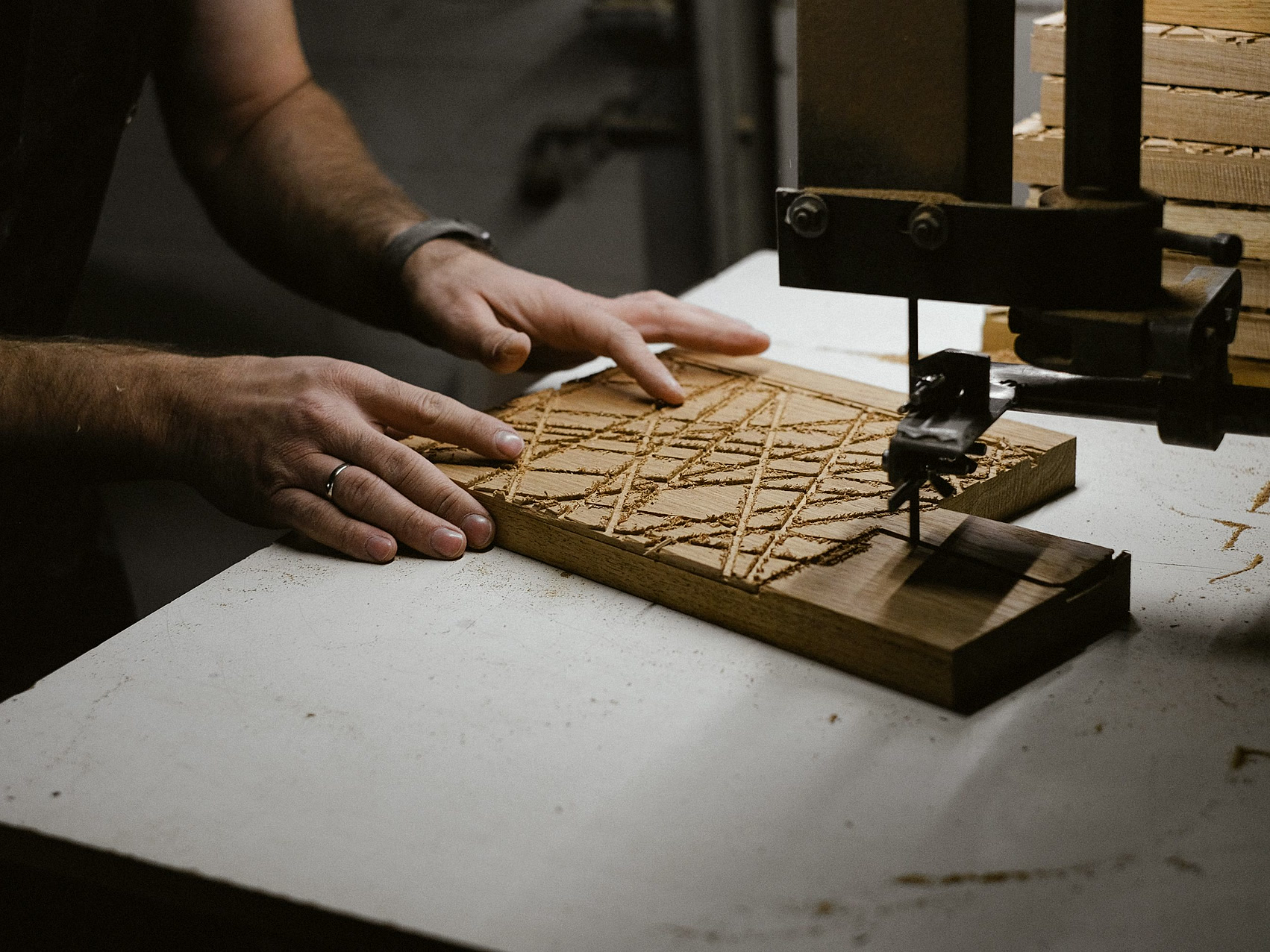 Artisan carving a wooden panel by hand in the workshop