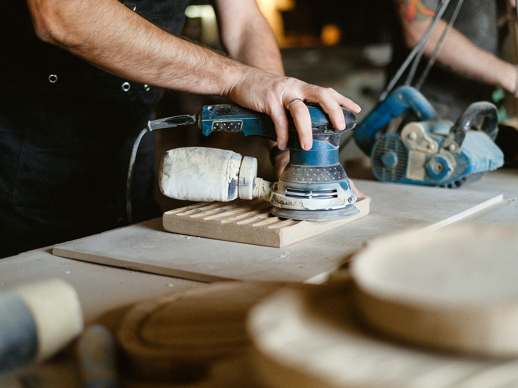 Woodworker sanding a furniture surface to a consistent finish
