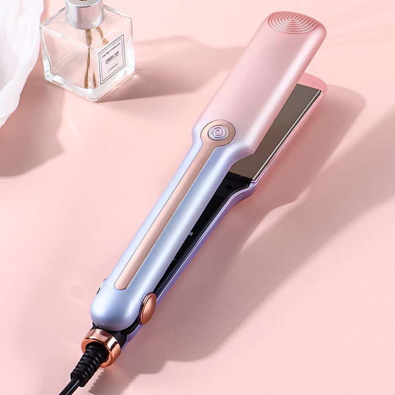 Single pink and lilac hair straightener open on pink background.