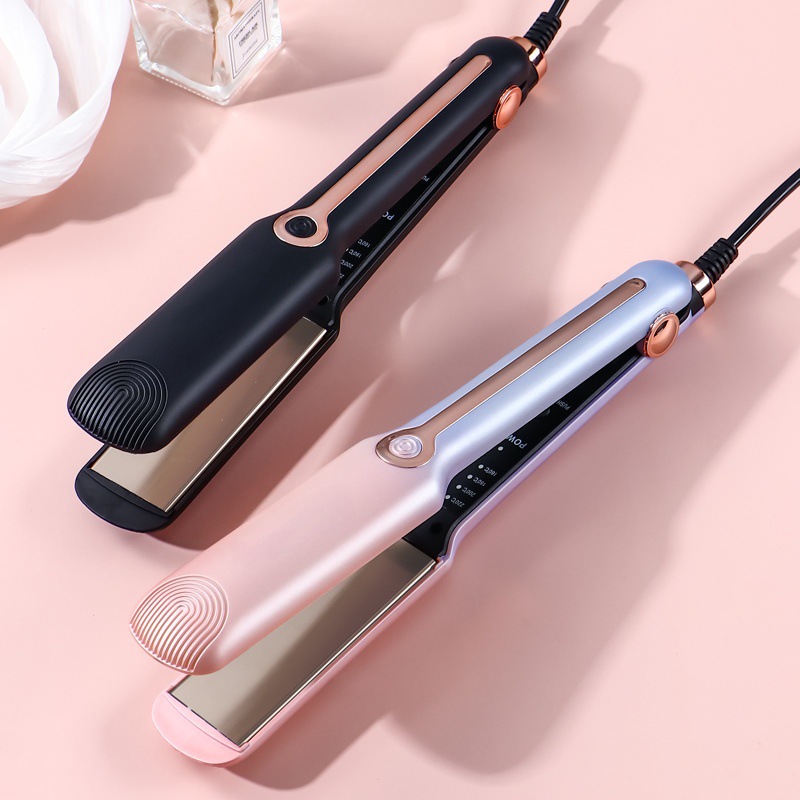 Black and pink-lilac hair straighteners side by side on pink surface.