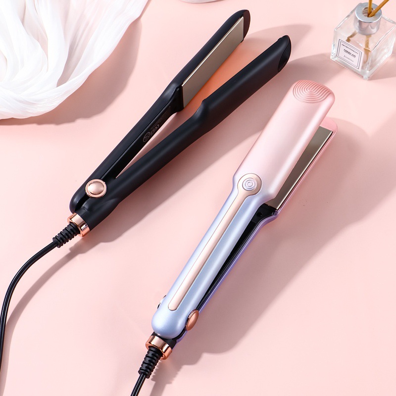 Black and pink-lilac hair straighteners arranged diagonally on pink surface.