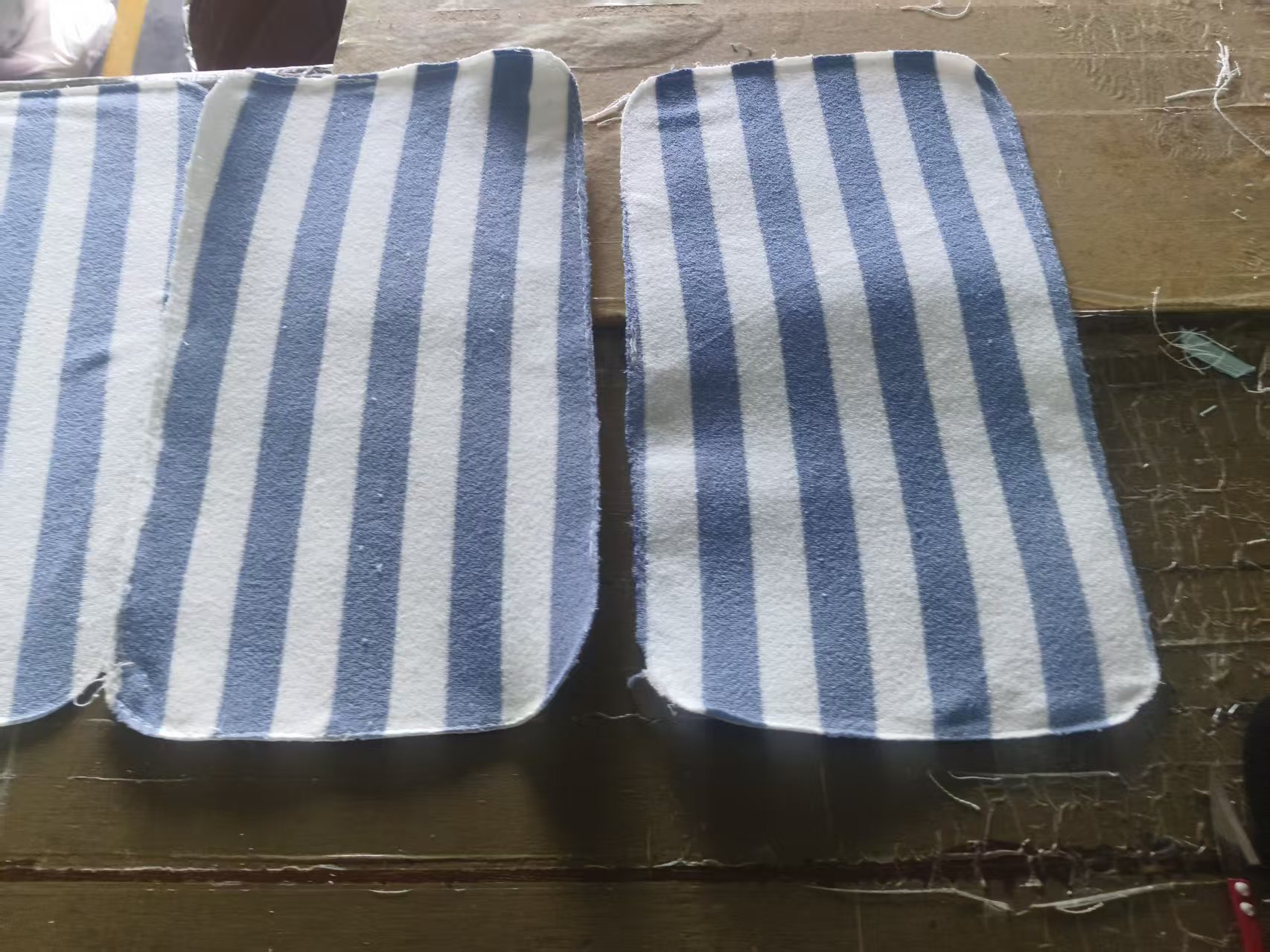 Striped terry cosmetic bag cut panels on a factory worktable during development