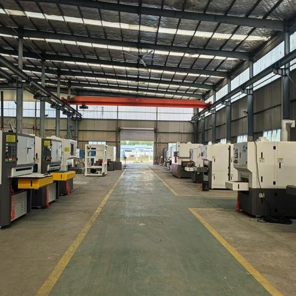 Metal finishing machines arranged along a workshop aisle.