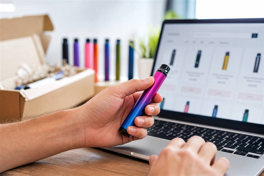 adult shopper holding a disposable vape while browsing VAPES-AUS