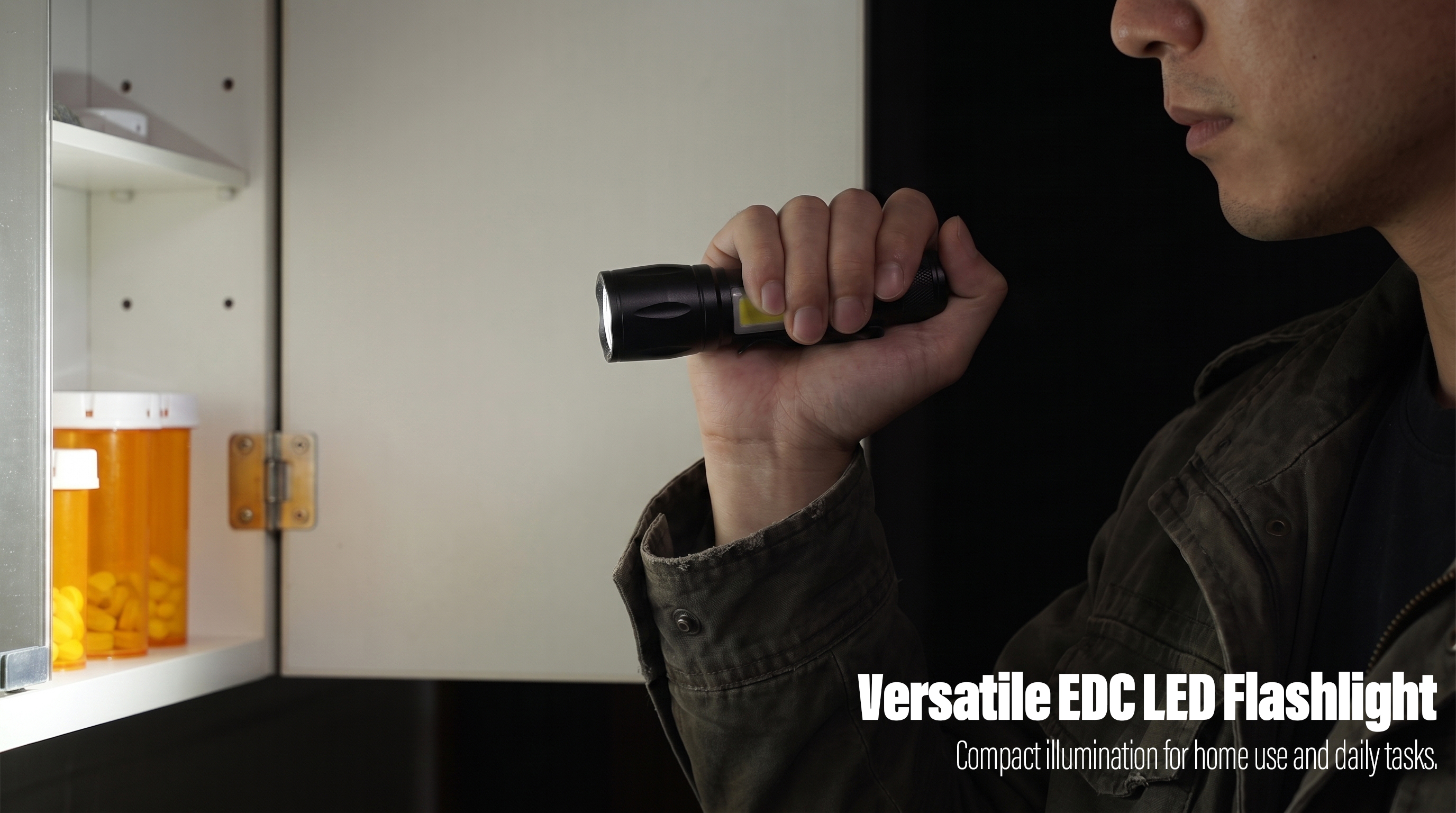 A man holds a compact black LED flashlight with a side COB light to illuminate the interior of a medicine cabinet.