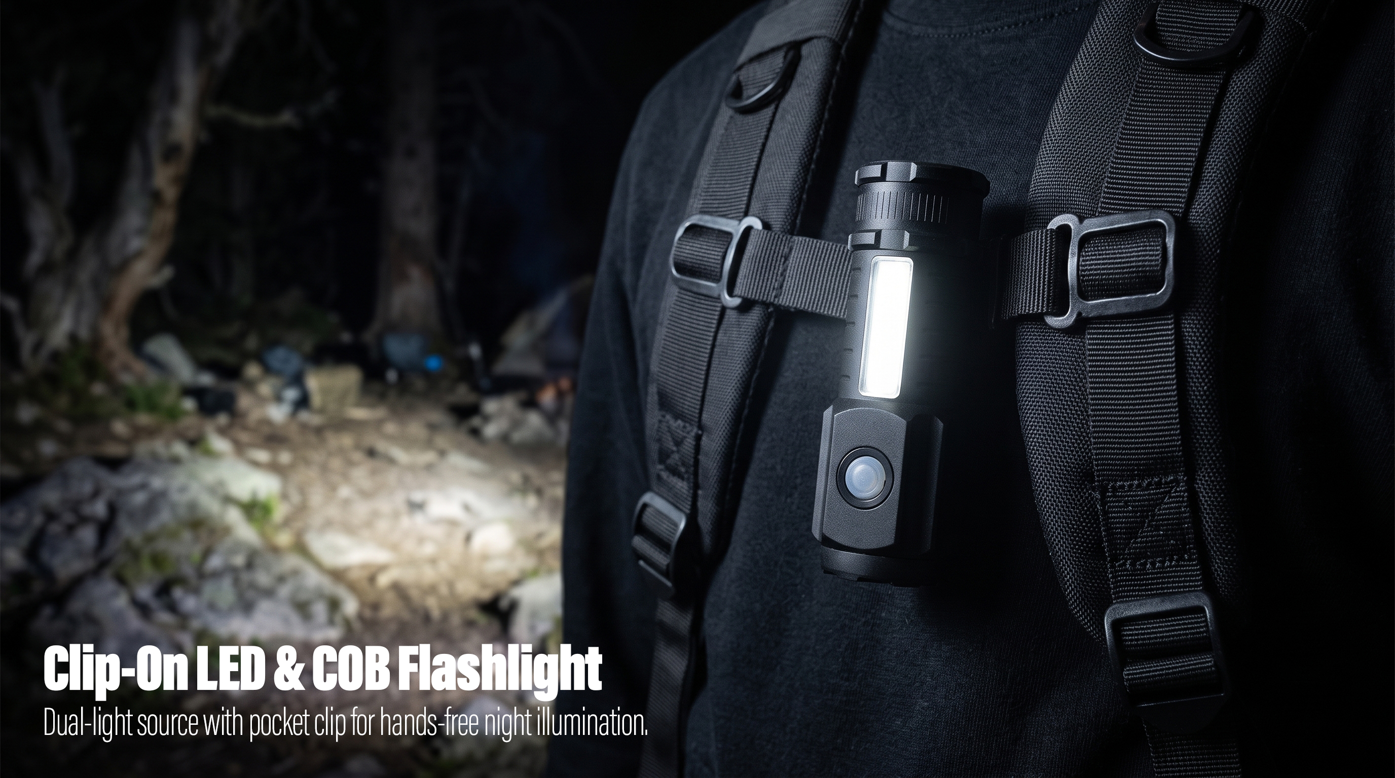 A black dual-light LED and COB flashlight with a pocket clip mounted on a backpack strap to light up a dark mountain trail.