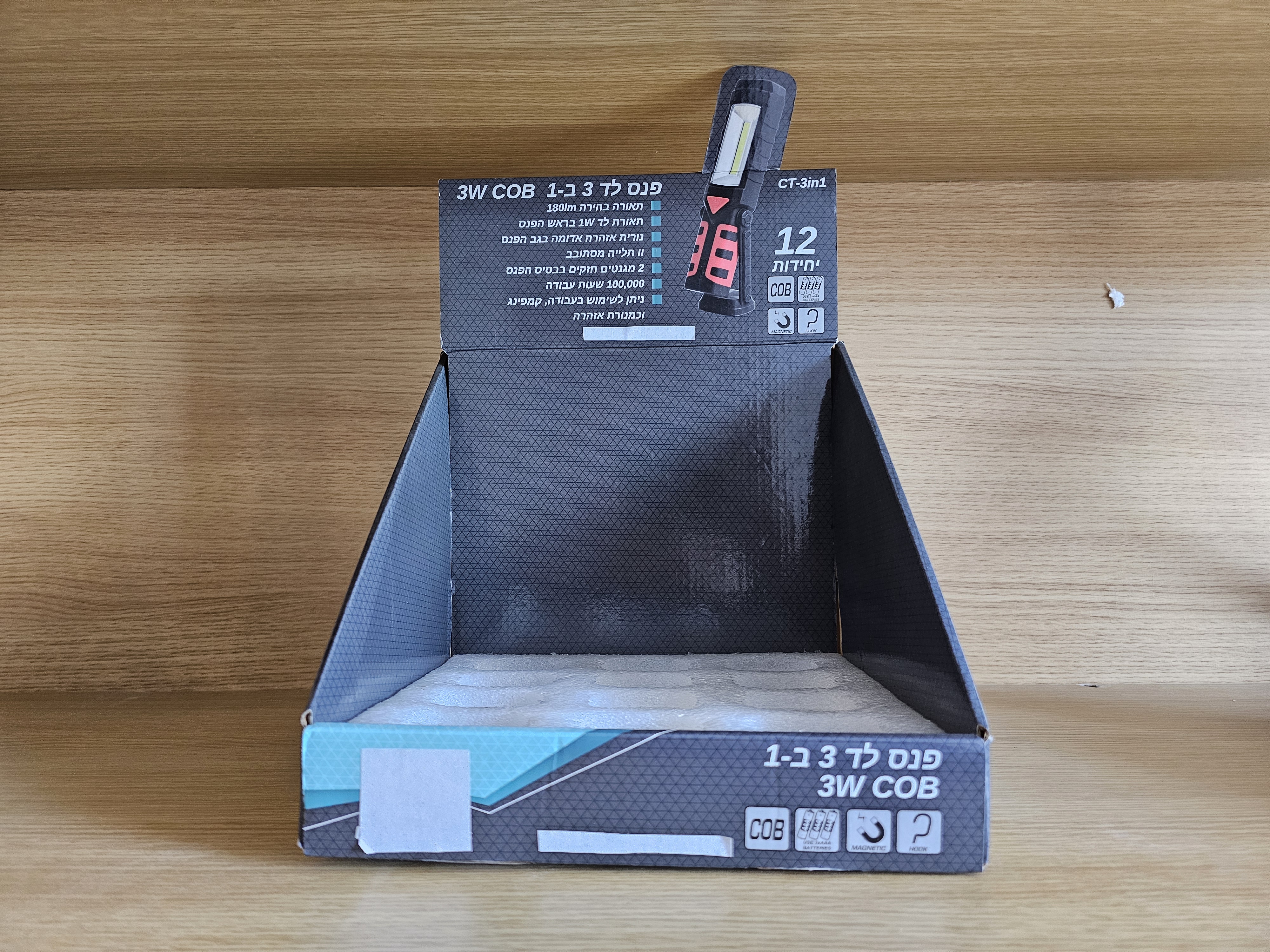 Empty counter display box for 3W COB LED work lights placed on a wooden shelf.