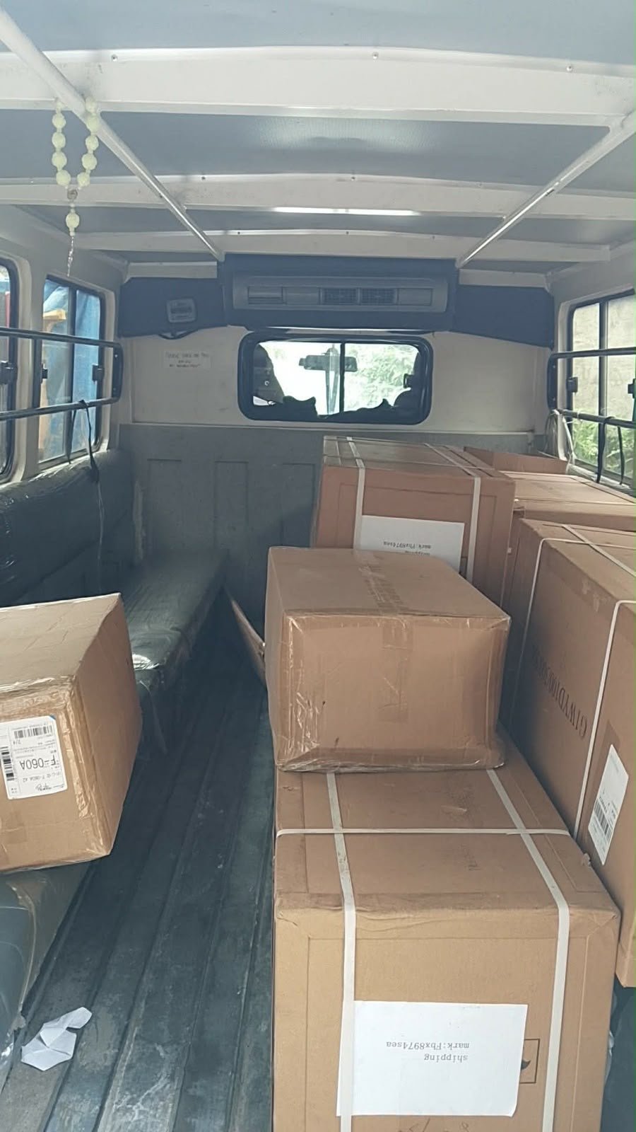 Interior of a vehicle with cardboard boxes stacked and secured for transportation.