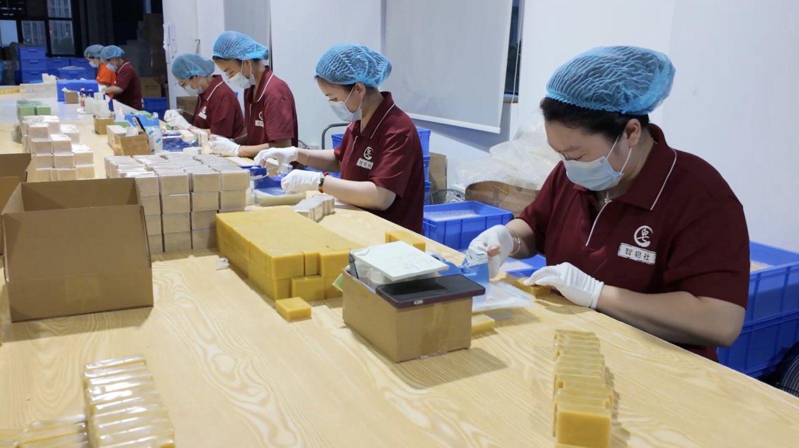 Soap bars and wrapping work at a packing table