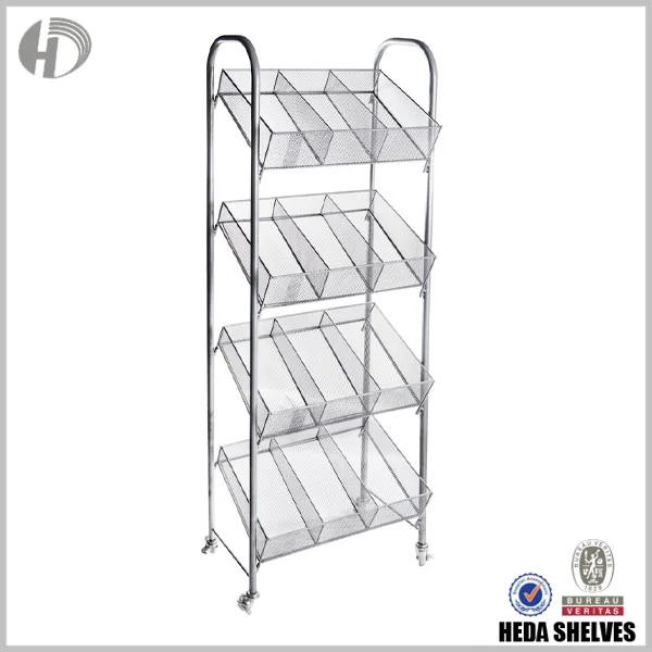Original HEDA No.00192 retail steel basket display fixture, angled view showing four tiers of partitioned silver metal mesh baskets, rounded tubular side frames and bottom caster wheels