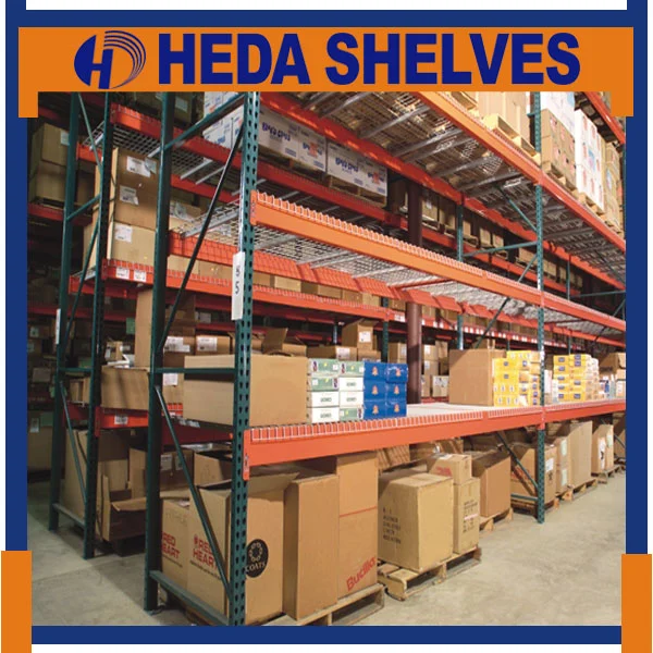 Original HEDA warehouse racking reference photograph showing blue and orange industrial storage racks with metal decking, palletized goods and stored cartons