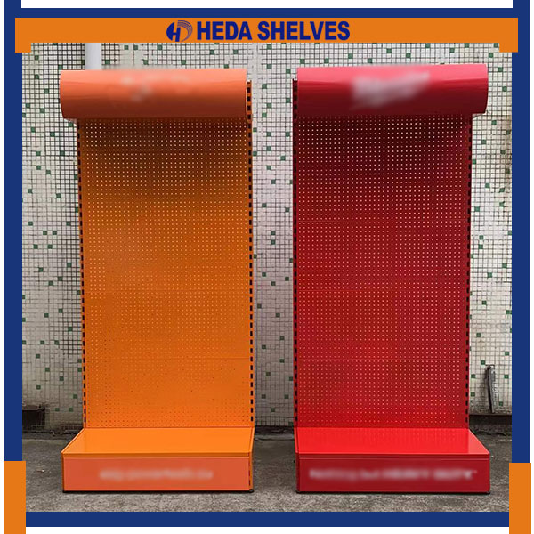 Original HEDA PDS06 factory comparison photograph showing two single-sided classic hardware pegboard display stands, one orange and one red, each with a curved upper canopy, perforated backboard and rectangular lower display platform