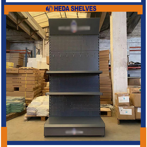 Original front-view photograph of HEDA PDS02 display stand with raised-logo top header, dark round-hole pegboard, metal hooks, two projecting shelves and a wide floor-level base