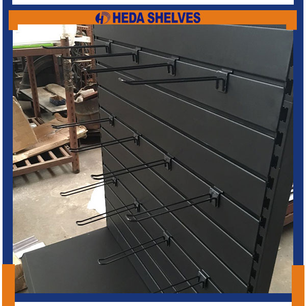 Genuine close-up of black metal wire display hooks installed in the horizontal grooves of the SWDR02 black slatwall panel
