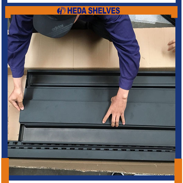 HEDA worker assembling the genuine SWDR02 black horizontal slatwall panels within the frame