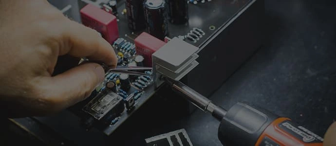 Engineer assembling electronics in a workshop.