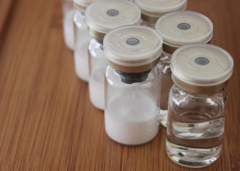 Light and fluffy freeze-dried powder stored in a sealed glass container, produced by a pilot-scale vacuum freeze dryer for food or pharmaceutical use