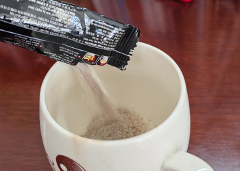 Powder drink stick pouch pouring into cup after strip packing