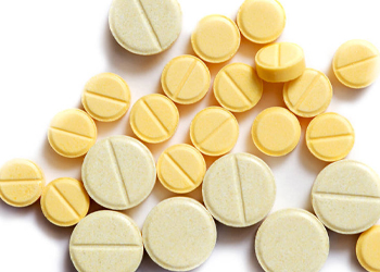 Yellow and off-white polished tablets from a tablet polishing machine