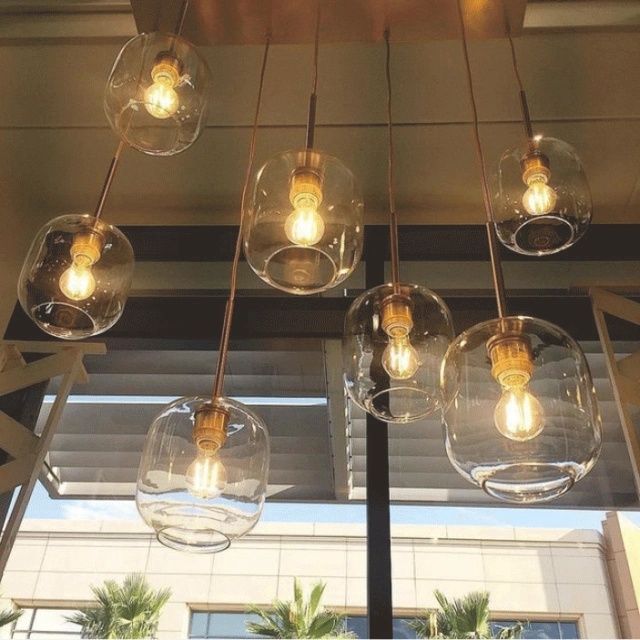 Mid Century Modern Glass Jar Pendant Light in Brass Over Kitchen Island Dining Table and Breakfast Bar Lighting