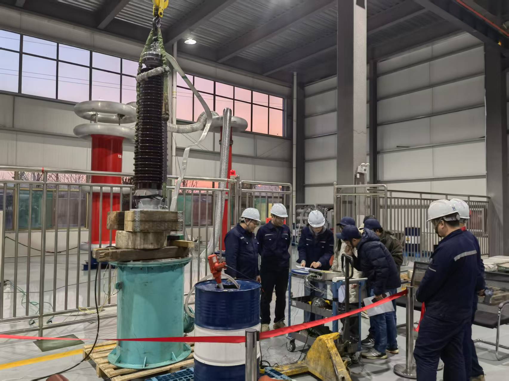 Technicians working beside a large bushing in a high-voltage test area