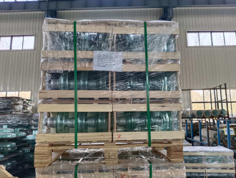 Glass insulators stacked on blue pallets and secured with stretch film