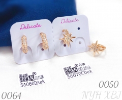 Gold-plated stud earrings in the shape of an octagonal star and a small sun.