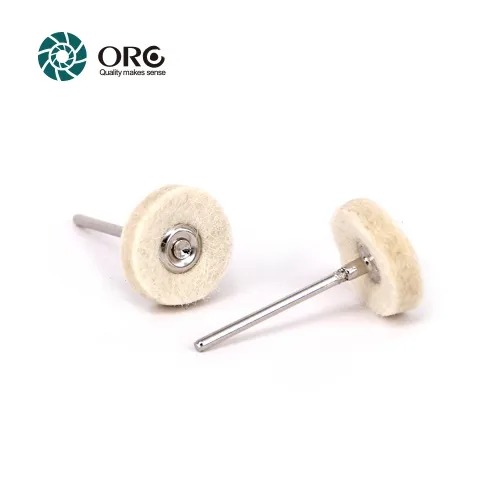 Two hard density round white wool felt wheels mounted on metal mandrels isolated on a clean white background